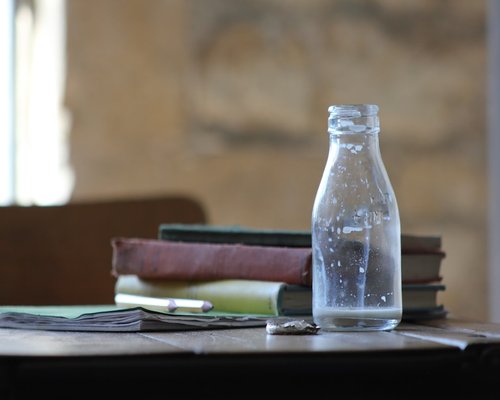 A glass of water and notebook on a desk