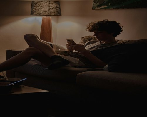 Man resting on a sofa reading